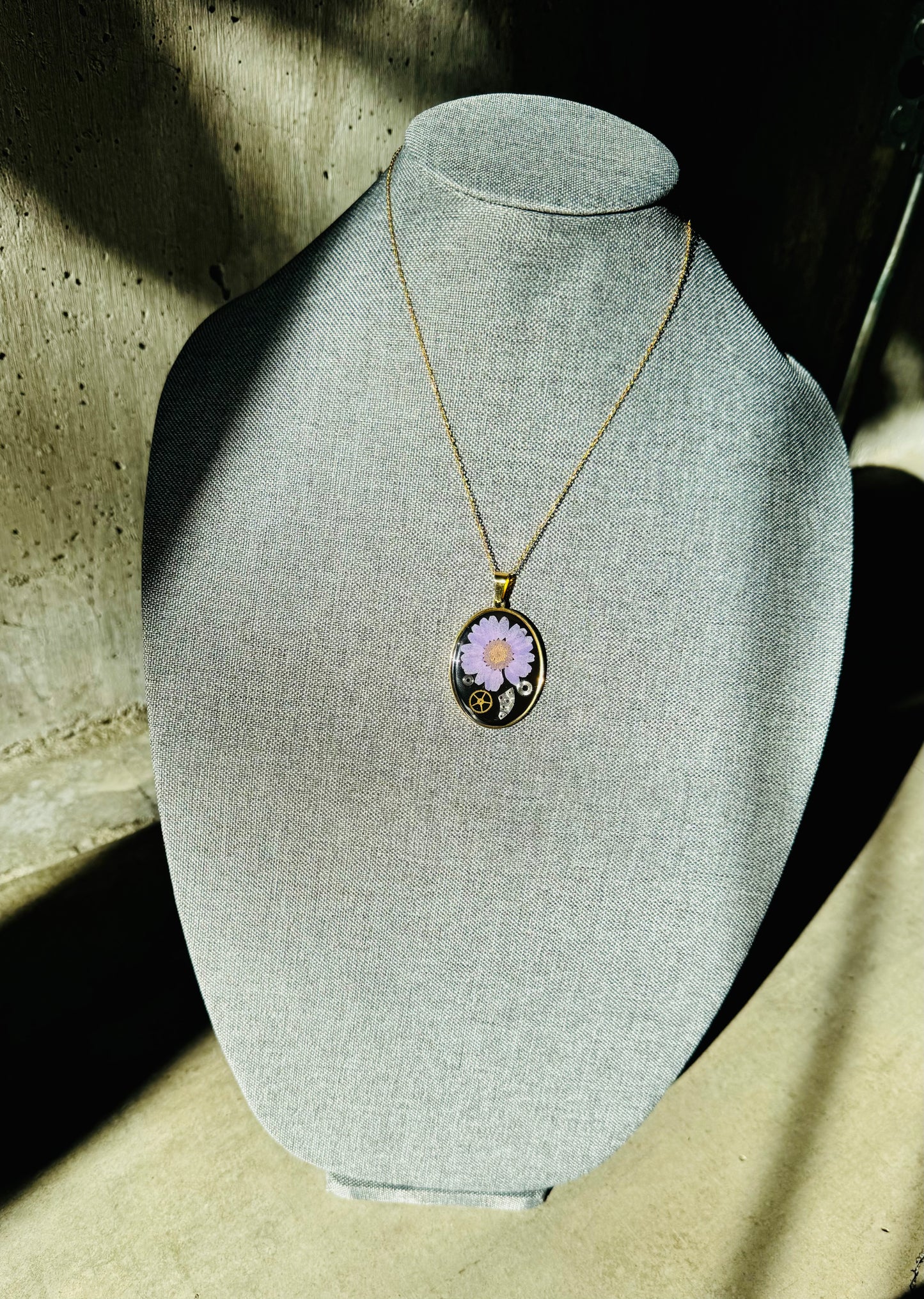 Oval necklace with purple daisy and watch parts