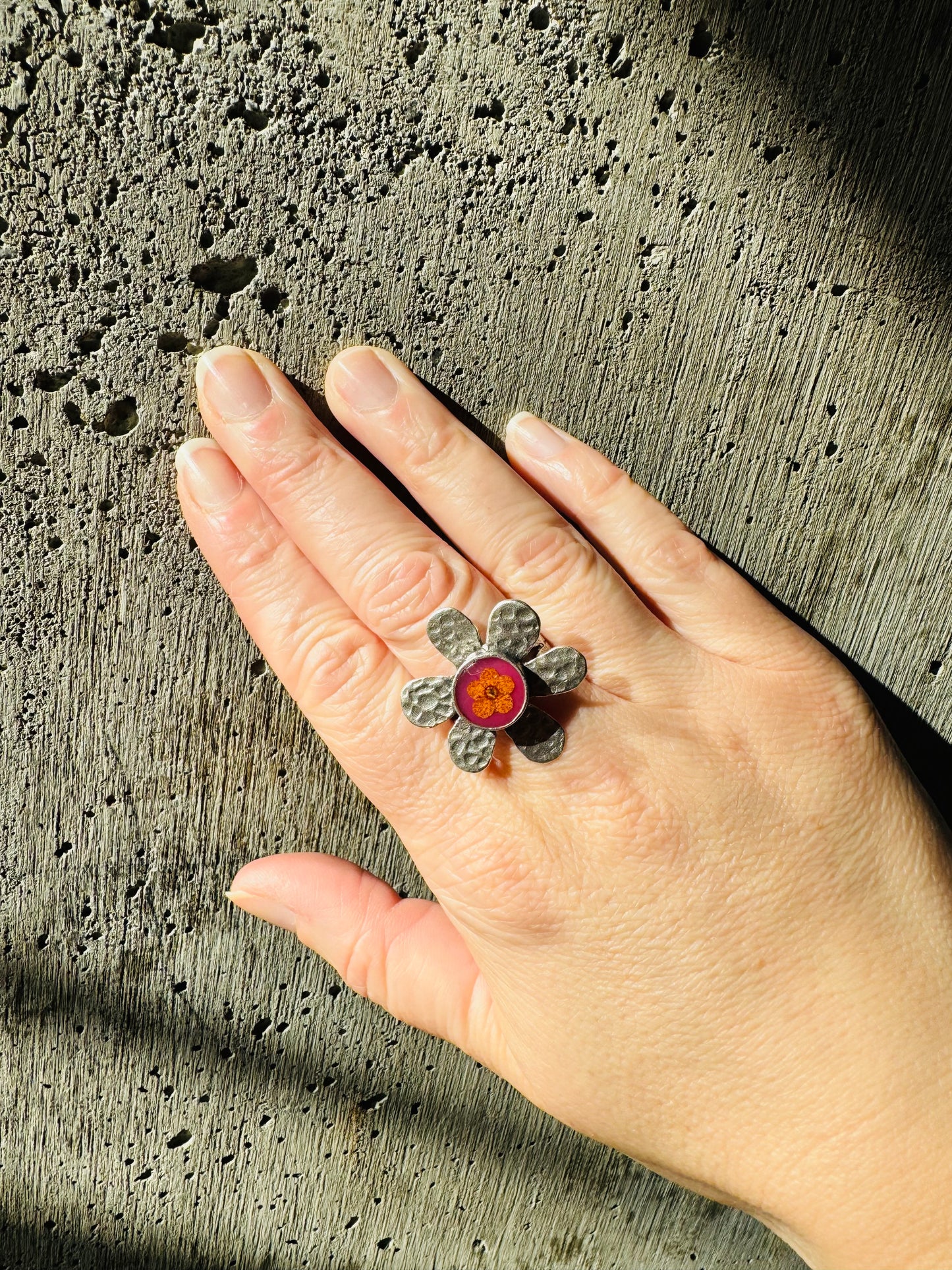 Flower silver ring with yellow flower on a pink background