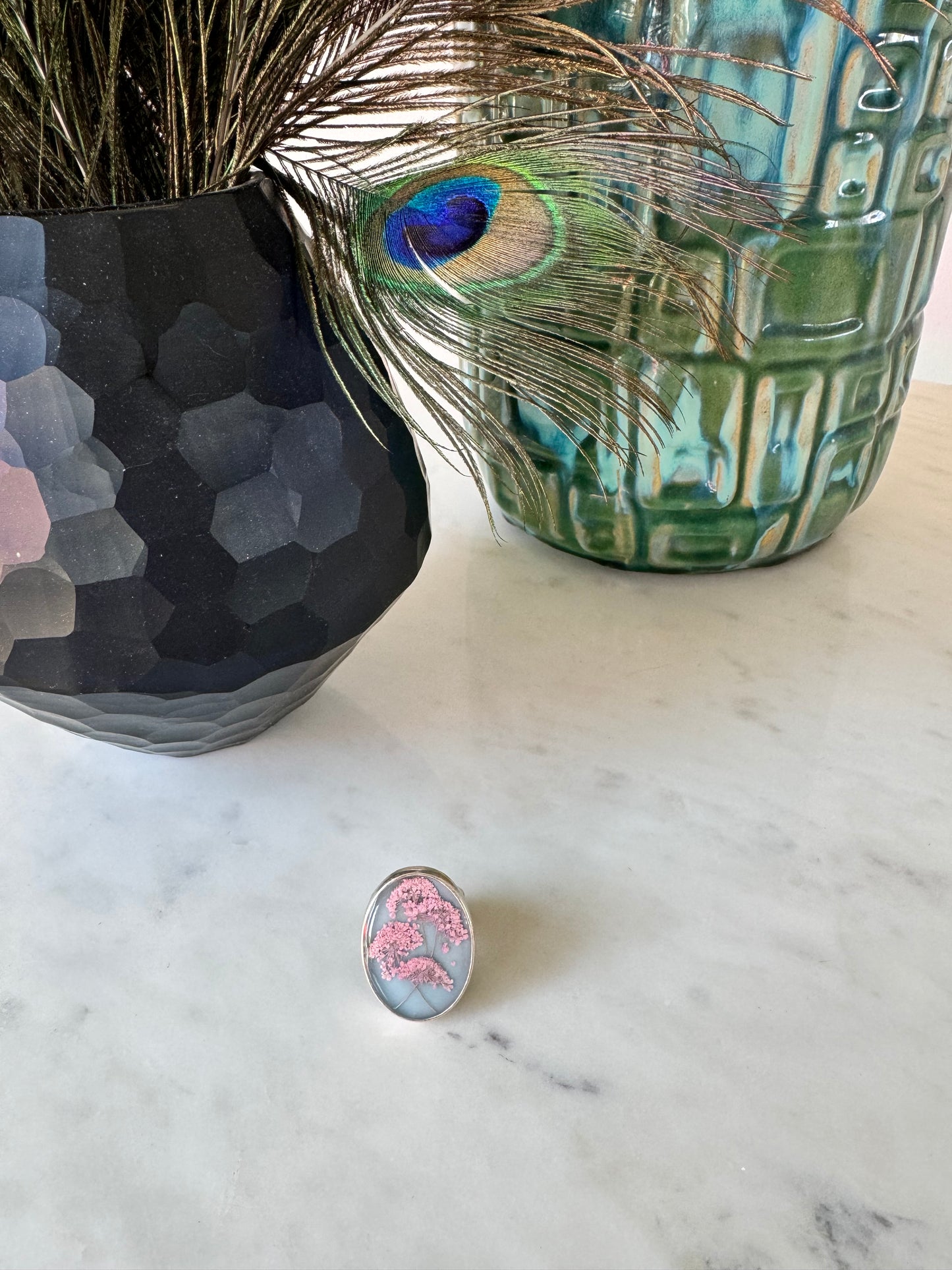 Oval ring with pink flowers on a blue background