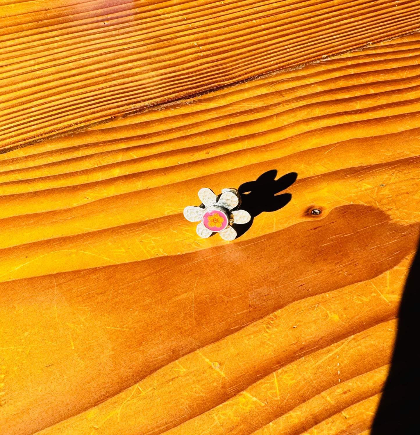 Flower silver ring with yellow flower on a pink background