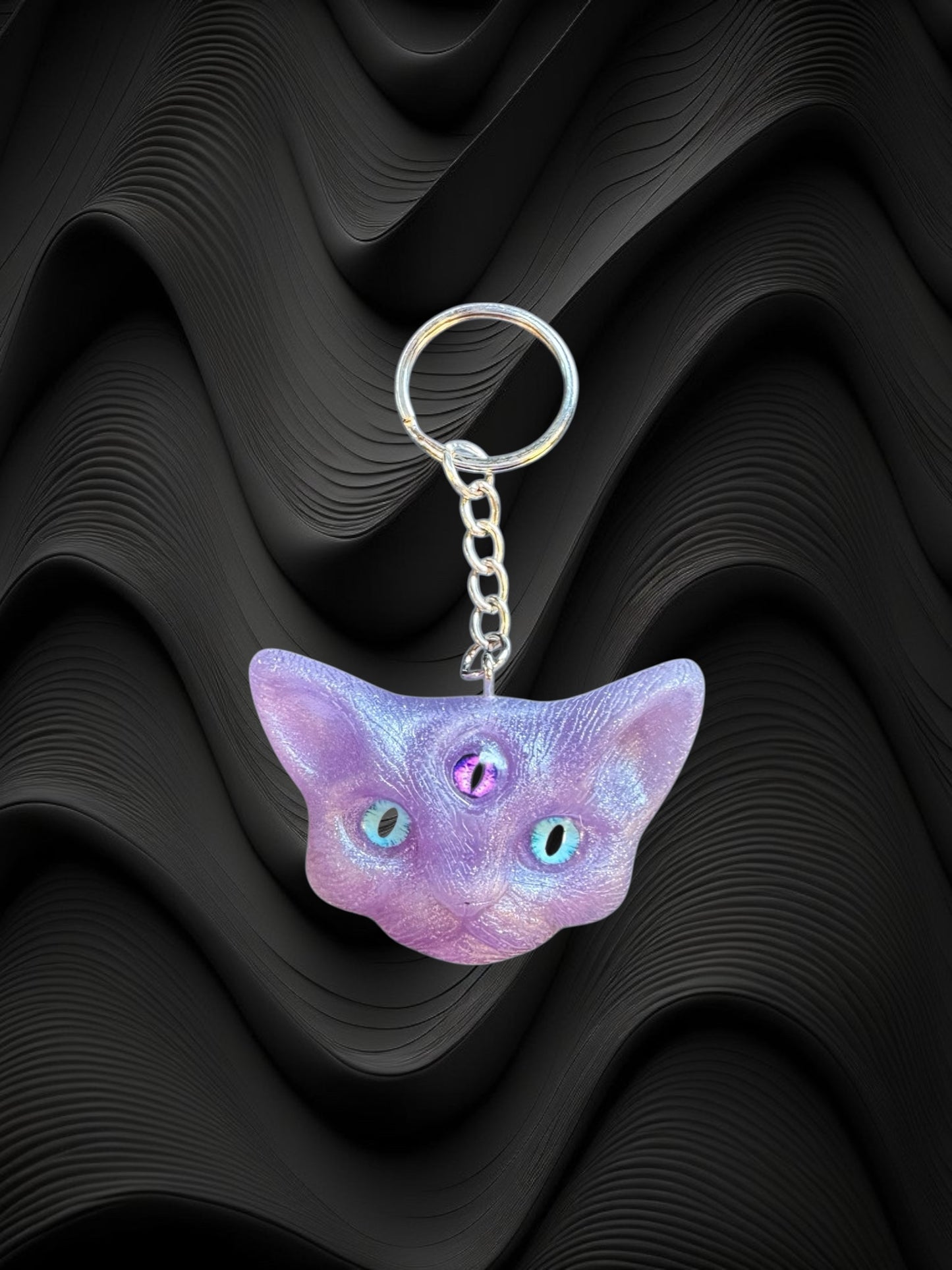 Three eyed cat keychain in purple