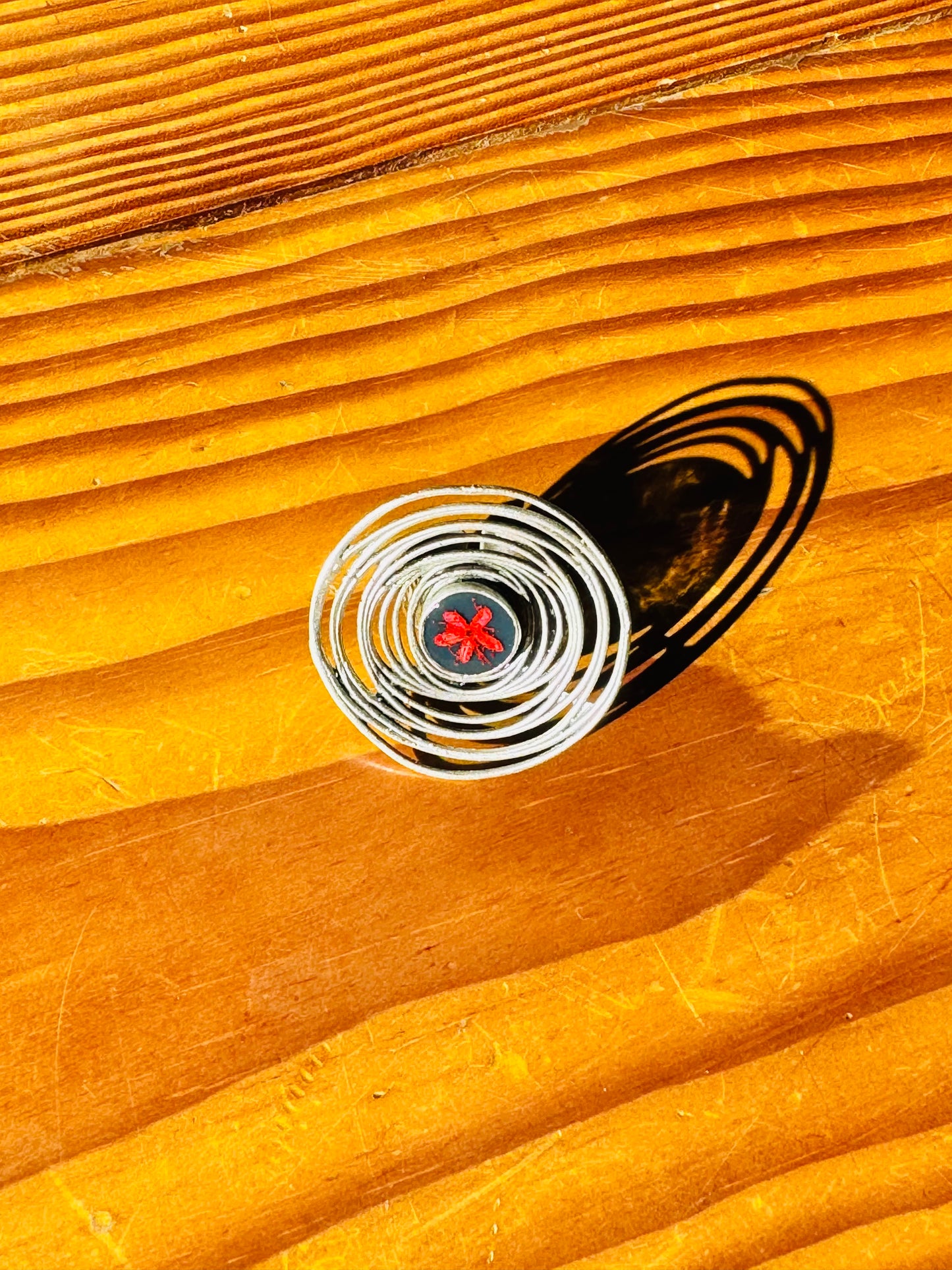 Oversized spiral silver ring with red flower on a navy background