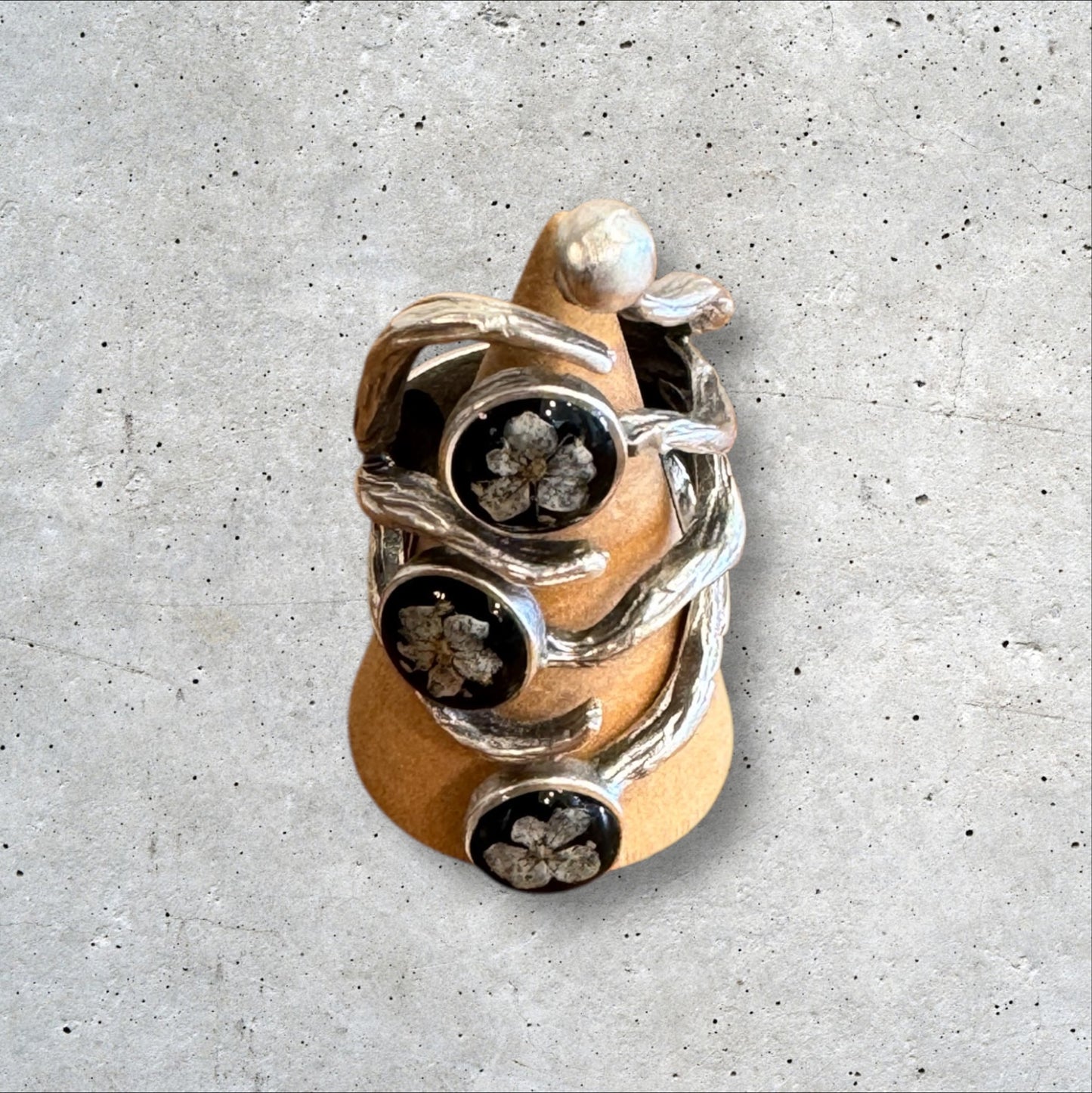 The roots ring with three white flowers on black background