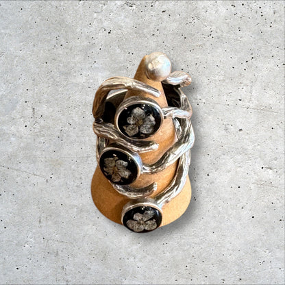 The roots ring with three white flowers on black background