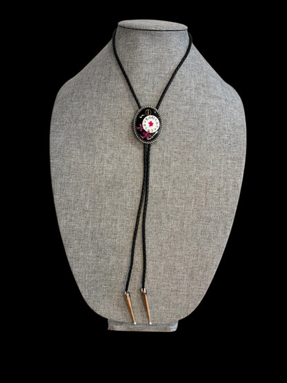 Bolo tie, pink flower and watch gears on black background