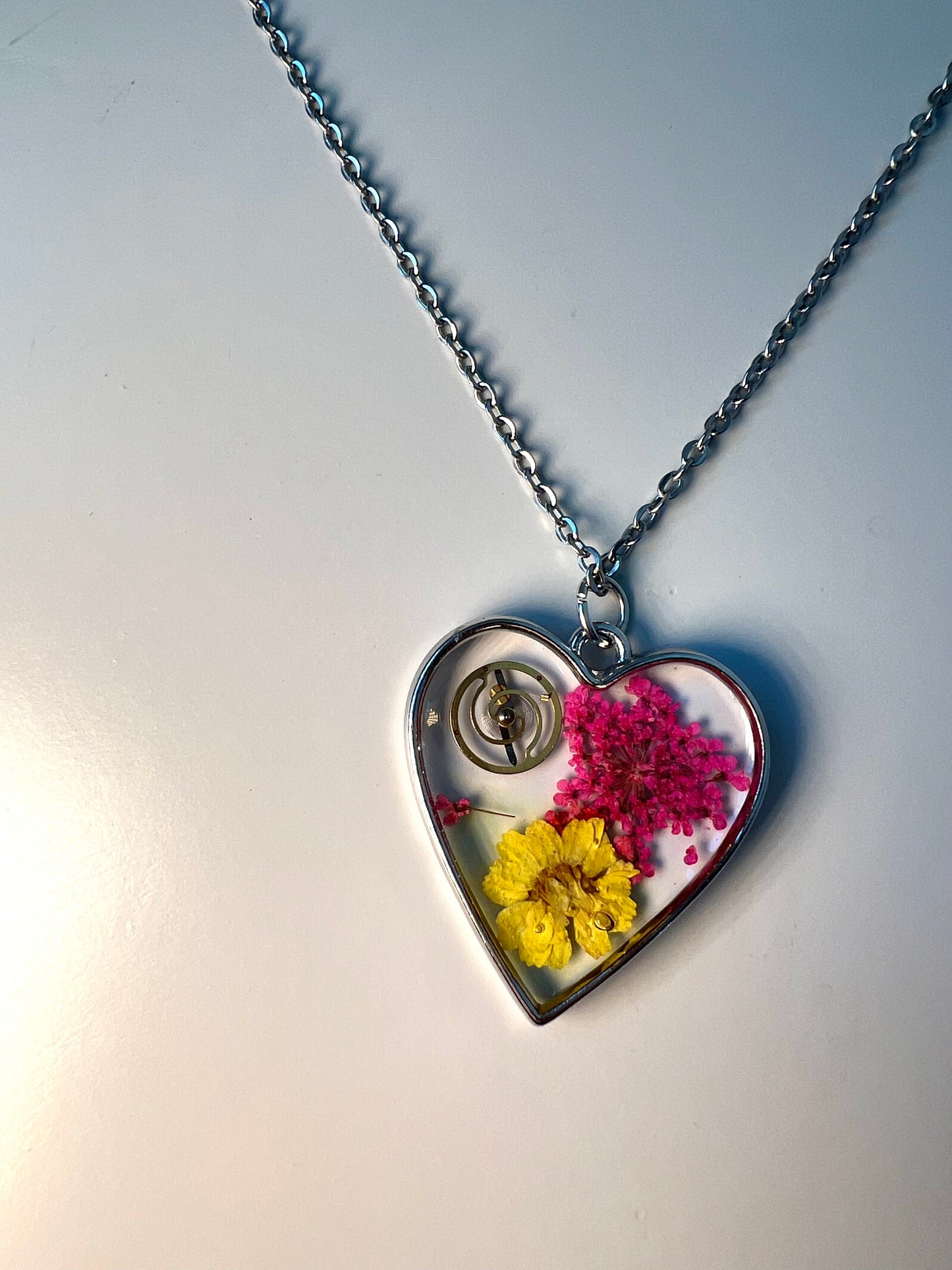 Heart necklace with pink and yellow flowers and watch part