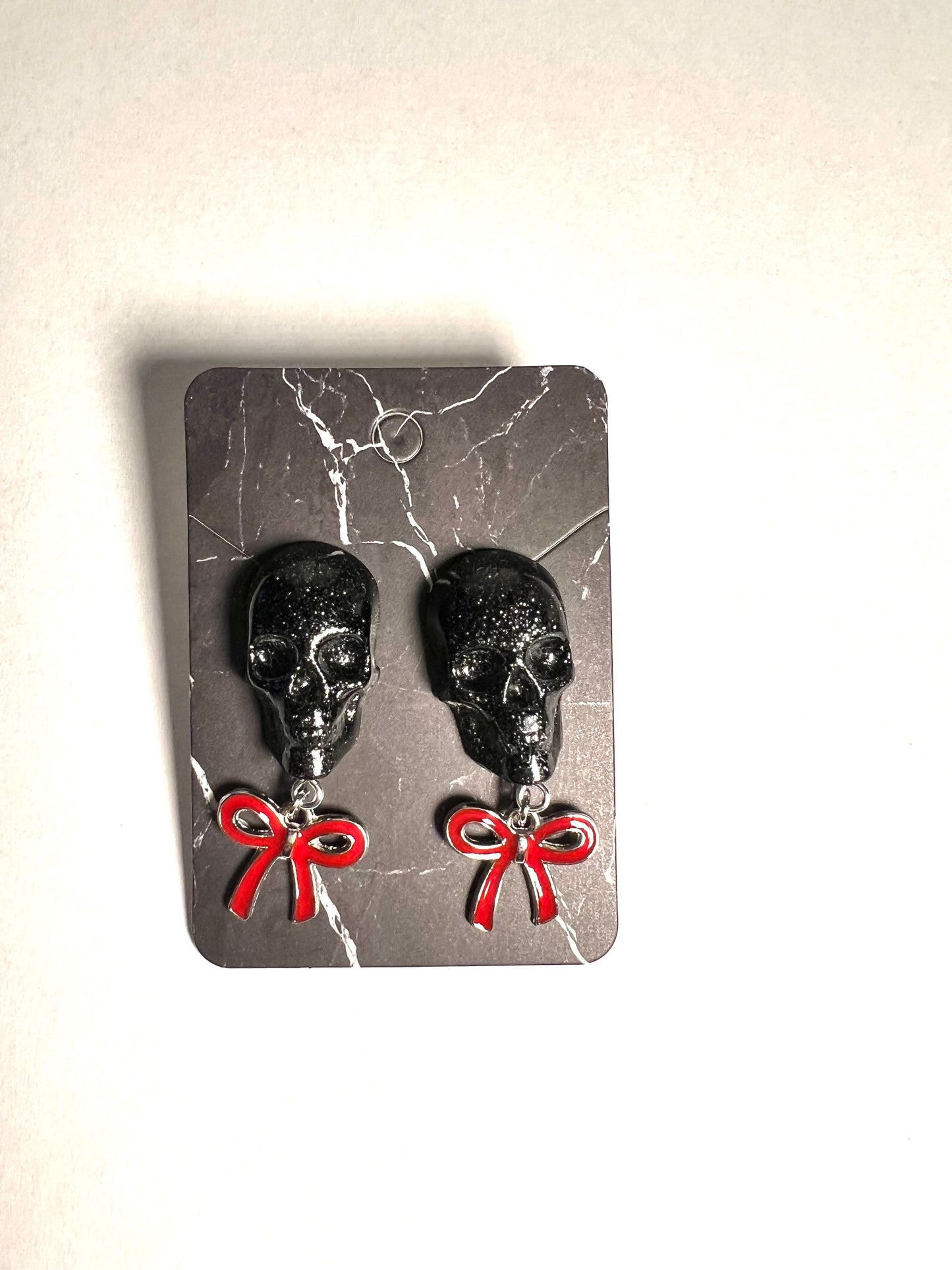 Skull with red bow and silver metal earrings studs