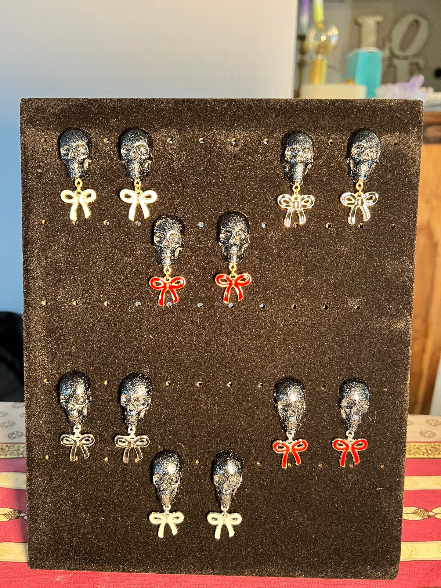 Skull with black bow and silver metal earrings studs