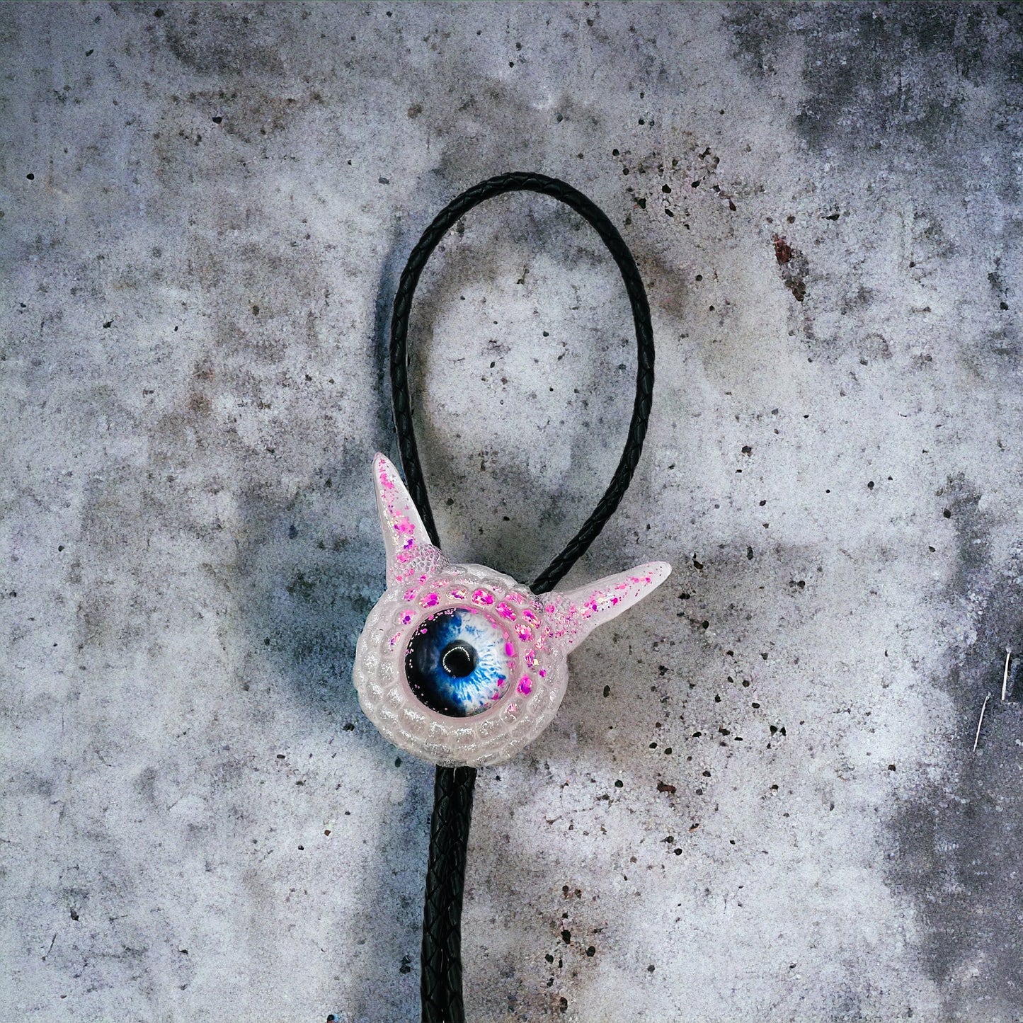 Monster bolo tie in white and pink. Model Pointy.