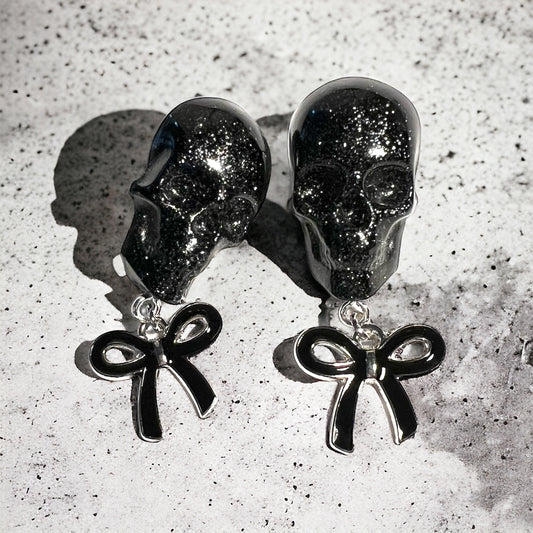 Skull with black bow and silver metal earrings studs