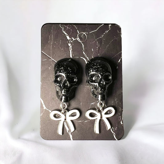 Skull with white bow and silver metal earrings studs
