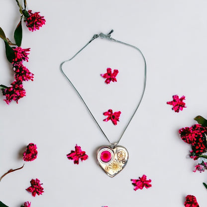 Large heart shape necklace with pink daisy, white Queen Anne lace and watch gear