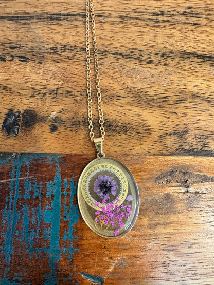 Oval necklace with purple and pink flowers and watch parts