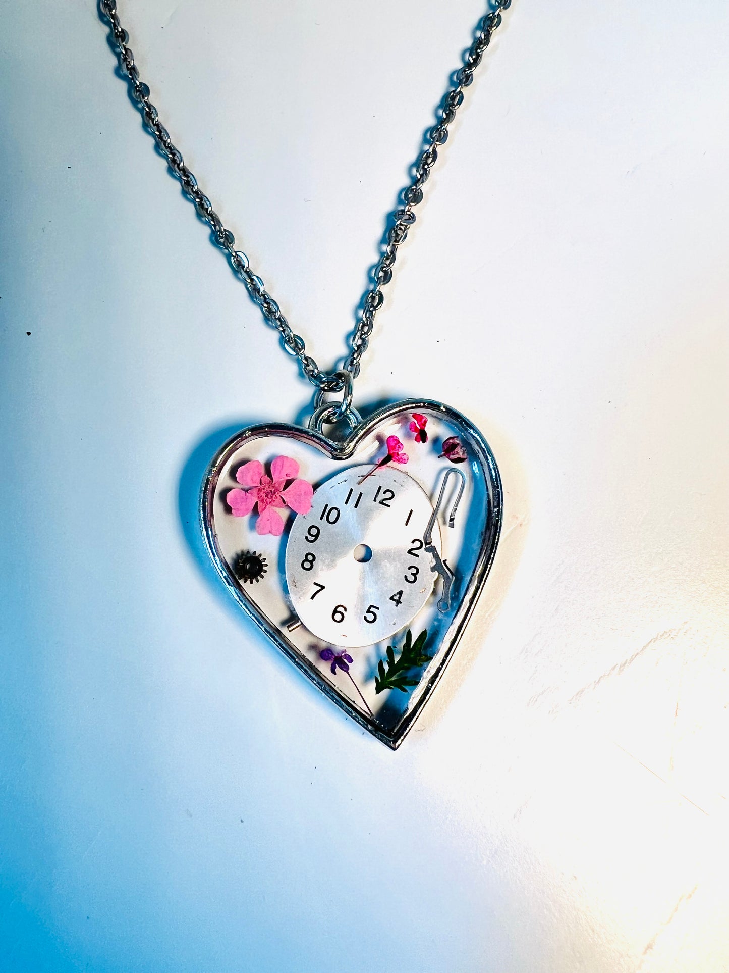 Heart necklace with pink flowers and watch face and gear