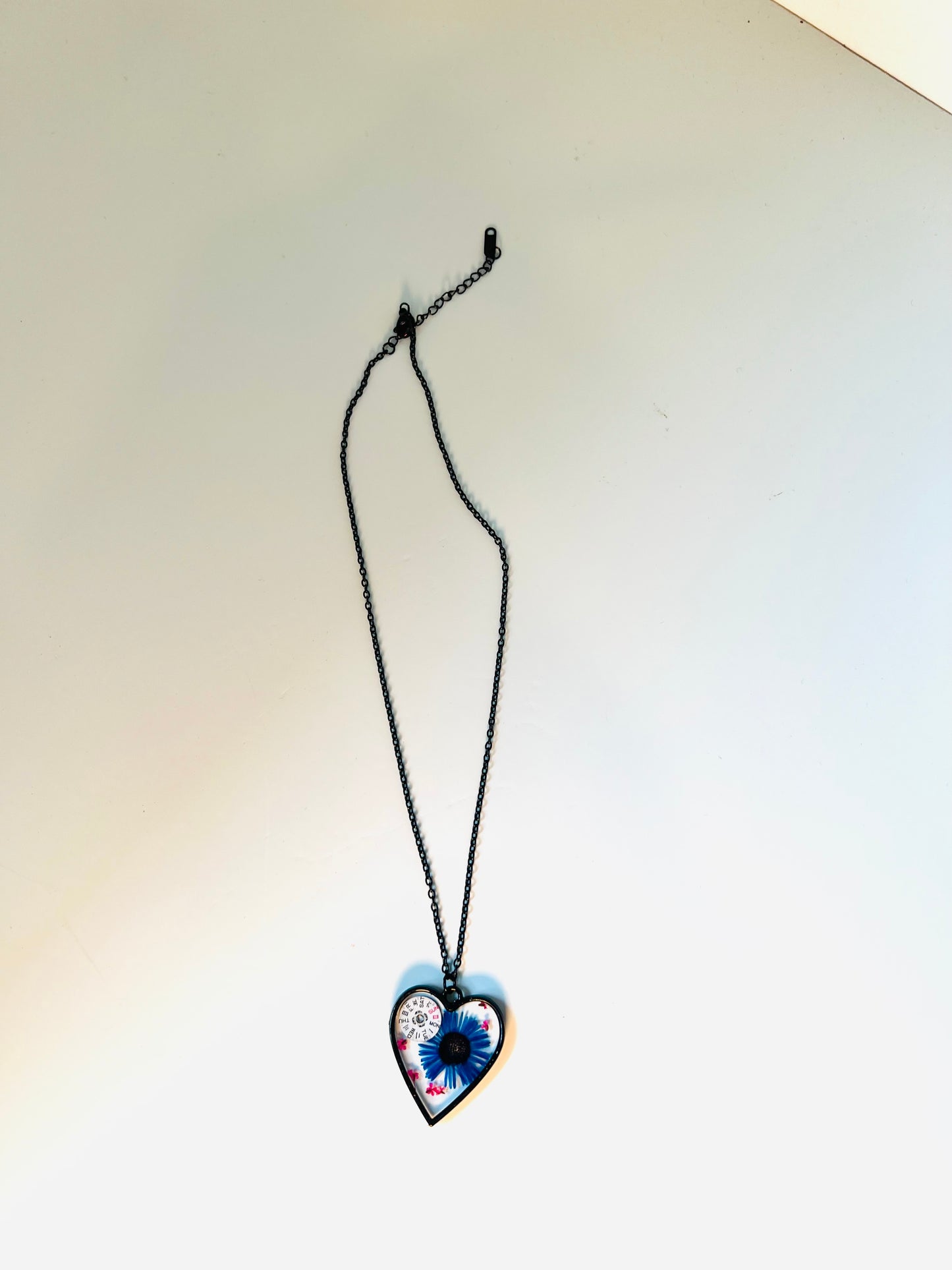 Black Heart necklace with blue chrysanthemum and pink Queen Anne lace flowers and watch parts