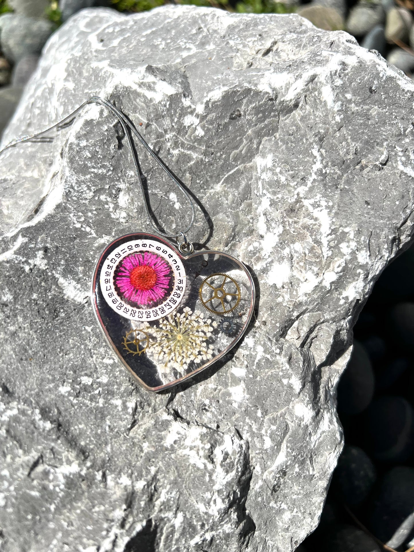 Large heart shape necklace with pink daisy, white Queen Anne lace and watch gear