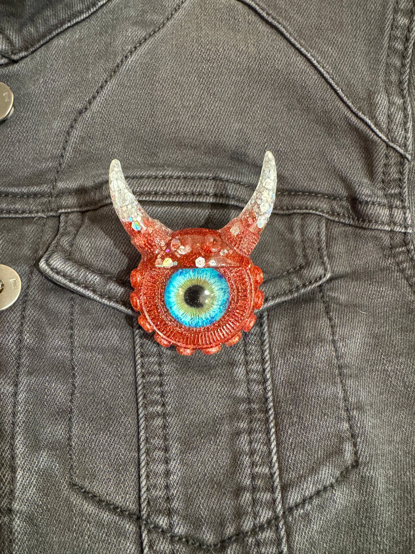 Monster brooch in silver and red. Model Vicky.