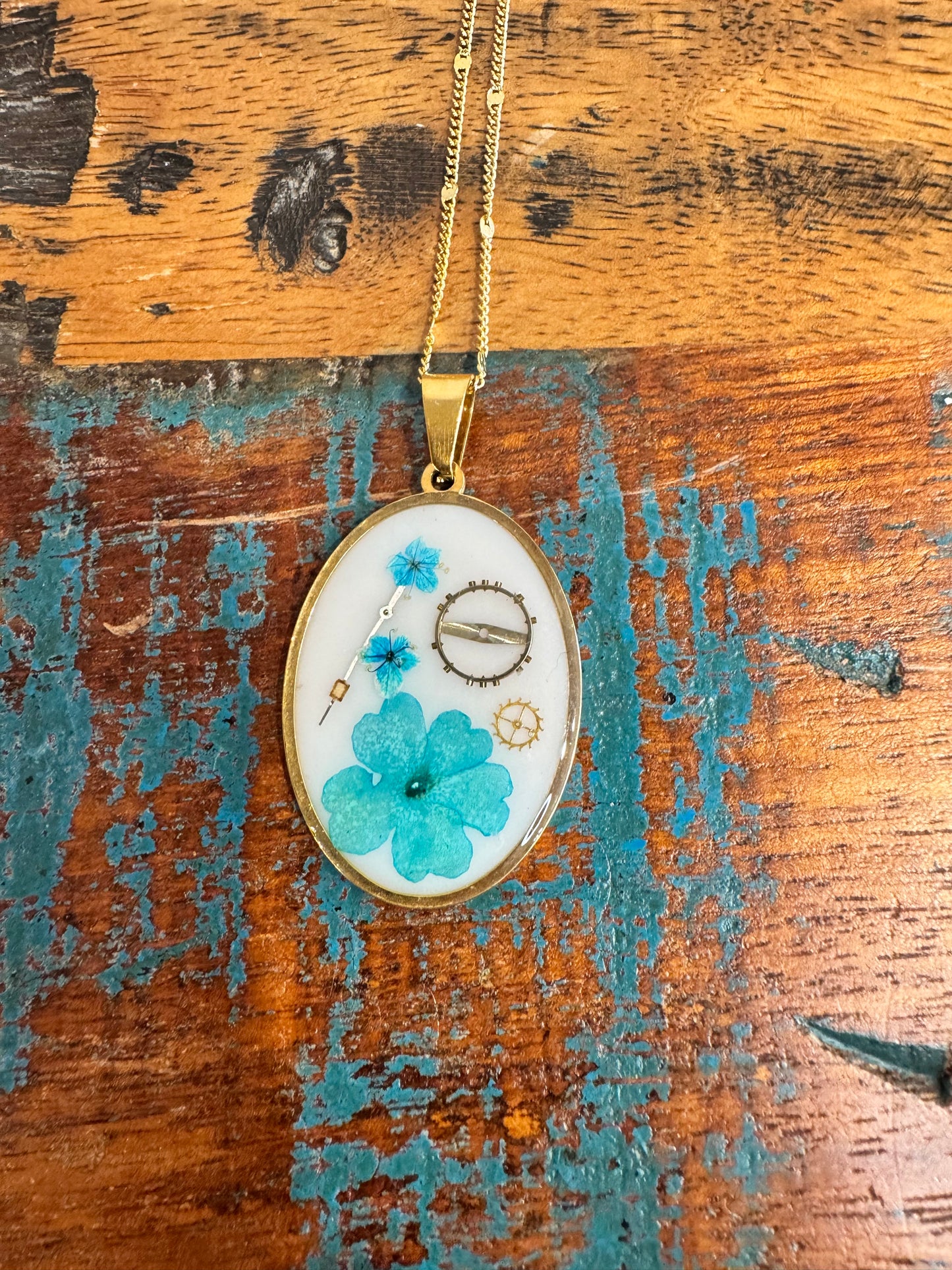 Oval necklace with blue flowers and watch parts