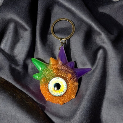 Creepy Monster Eye keychain, Orange, purple and green. Model Spiky.