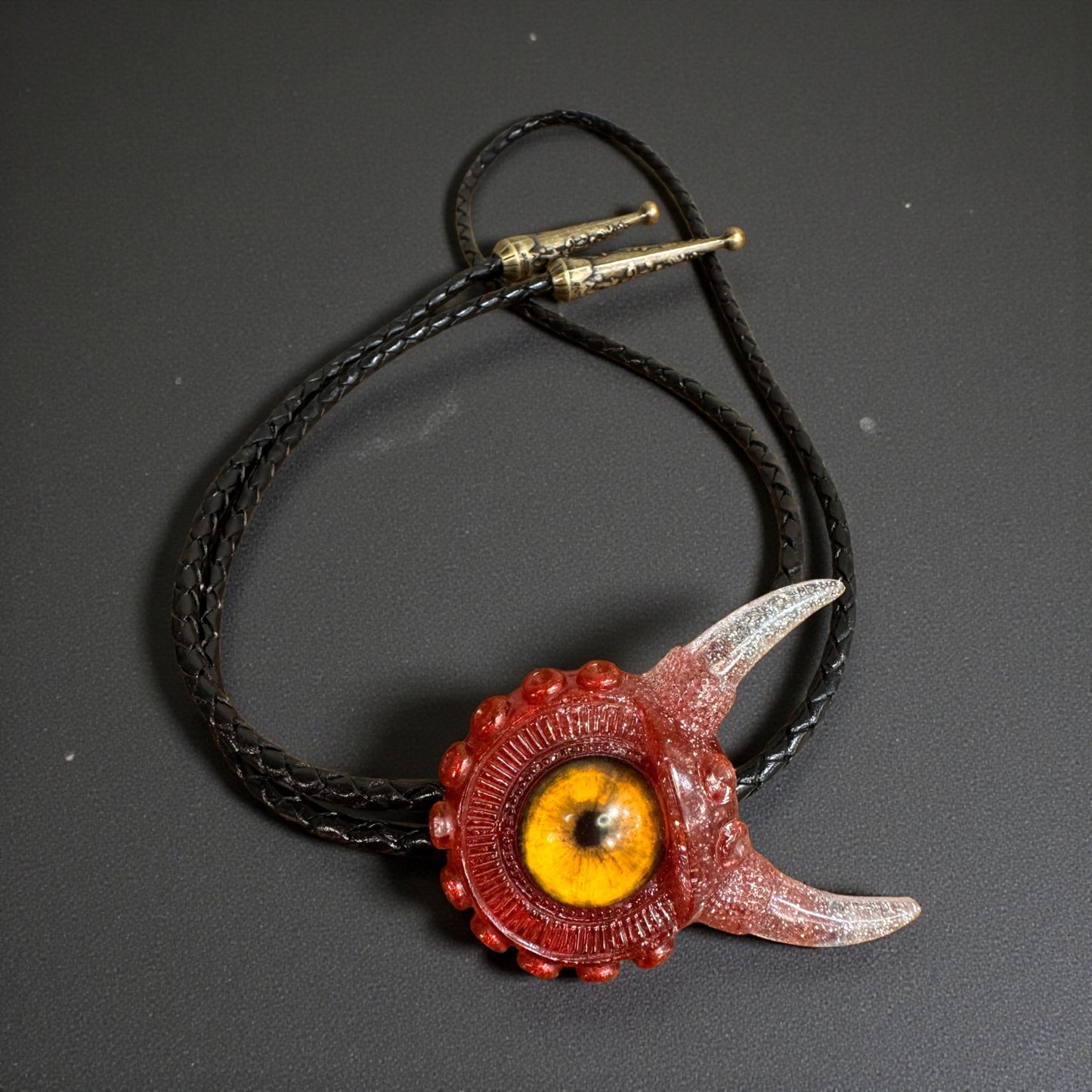 Monster bolo tie in red and silver. Model Vicky.