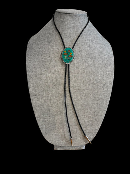 Bolo tie, red and yellow flowers and watch gears on a green background