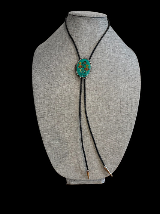 Bolo tie, red and yellow flowers and watch gears on a green background