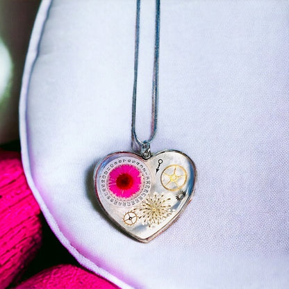 Large heart shape necklace with pink daisy, white Queen Anne lace and watch gear