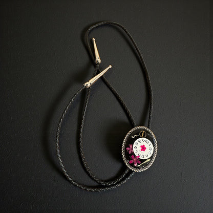 Bolo tie, pink flower and watch gears on black background