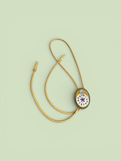 Bolo tie, purple flower and watch gears on gold background