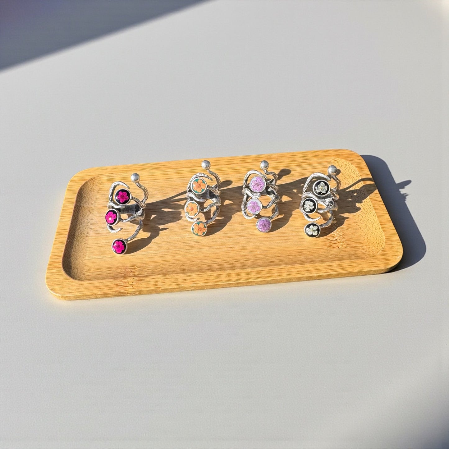 The roots ring with three pink flowers on black background