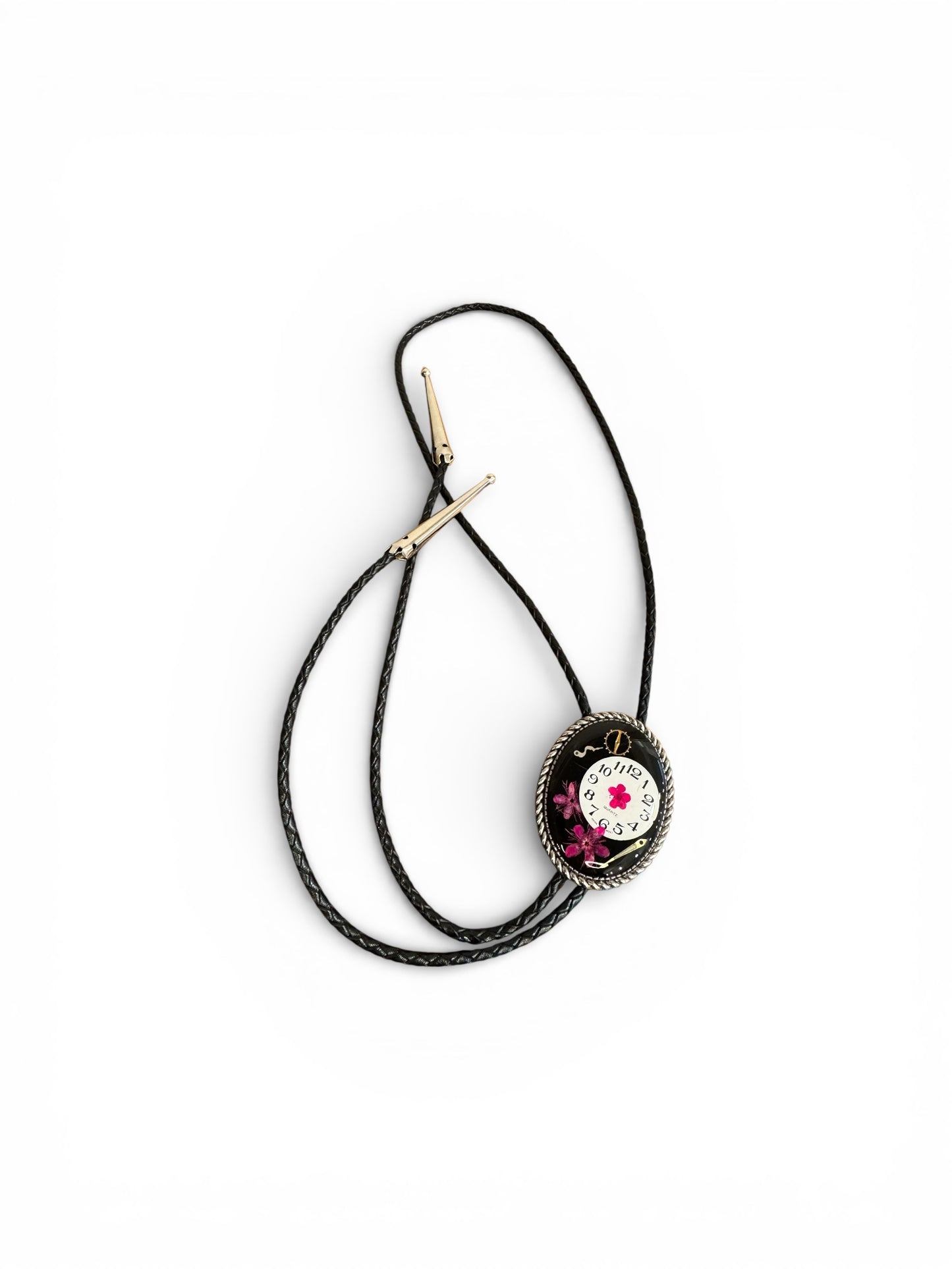 Bolo tie, pink flower and watch gears on black background