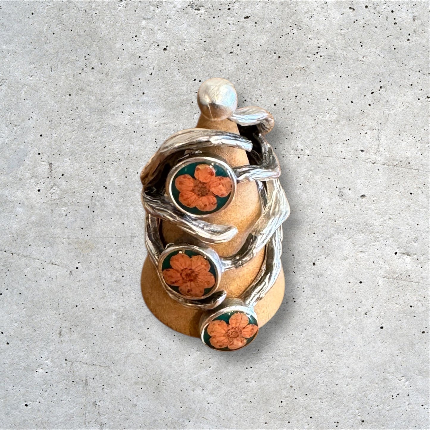 The roots ring with three orange flowers on green background