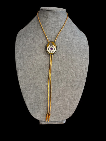 Bolo tie, purple flower and watch gears on gold background