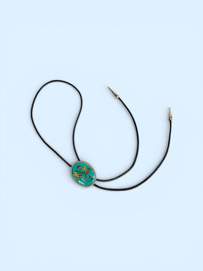 Bolo tie, red and yellow flowers and watch gears on a green background