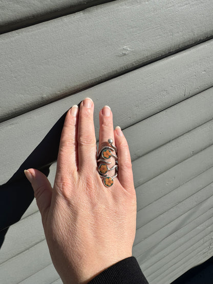 The roots ring with three orange flowers on green background
