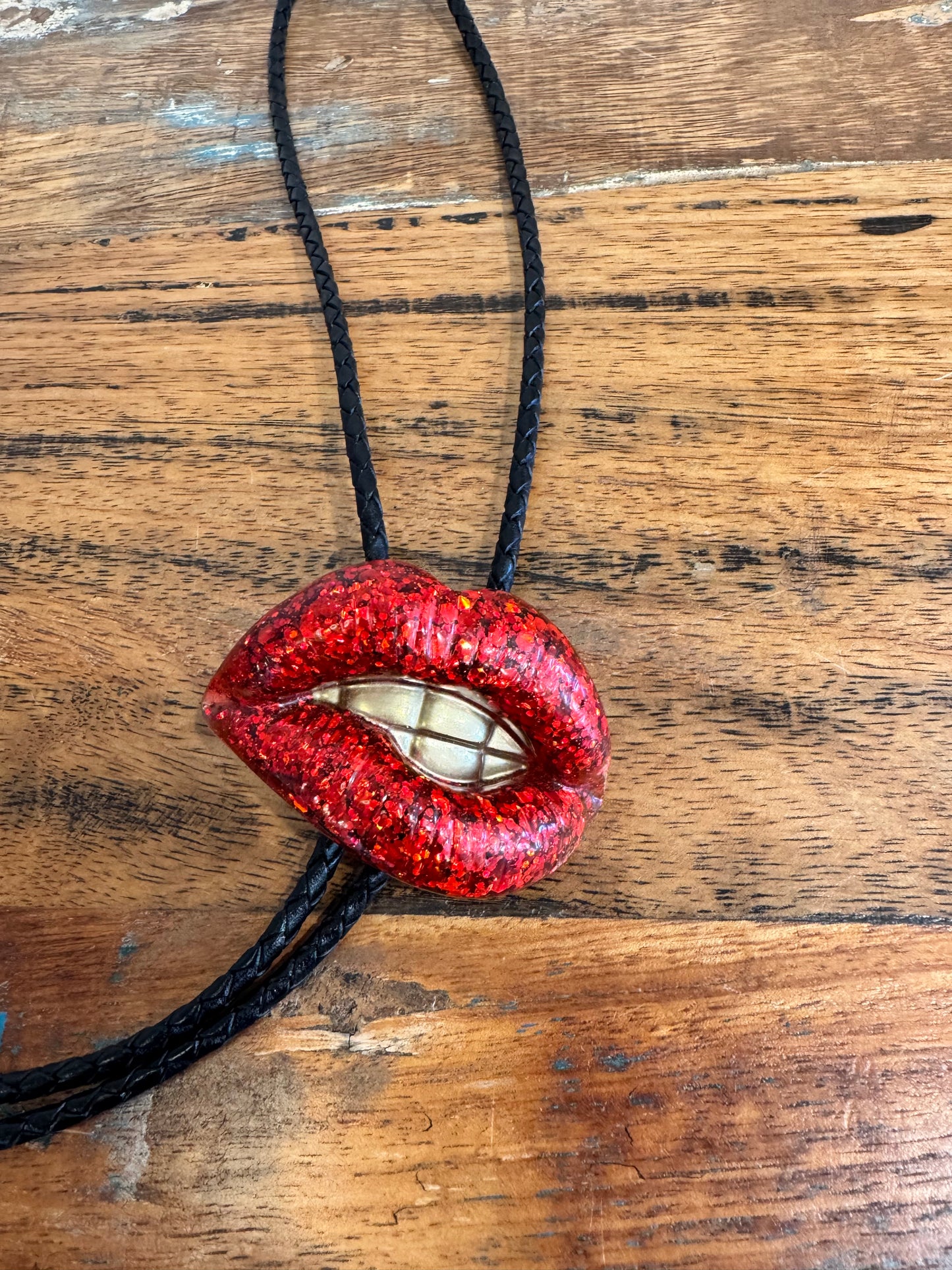 Bolo tie, sparkly red lips with gold teeth