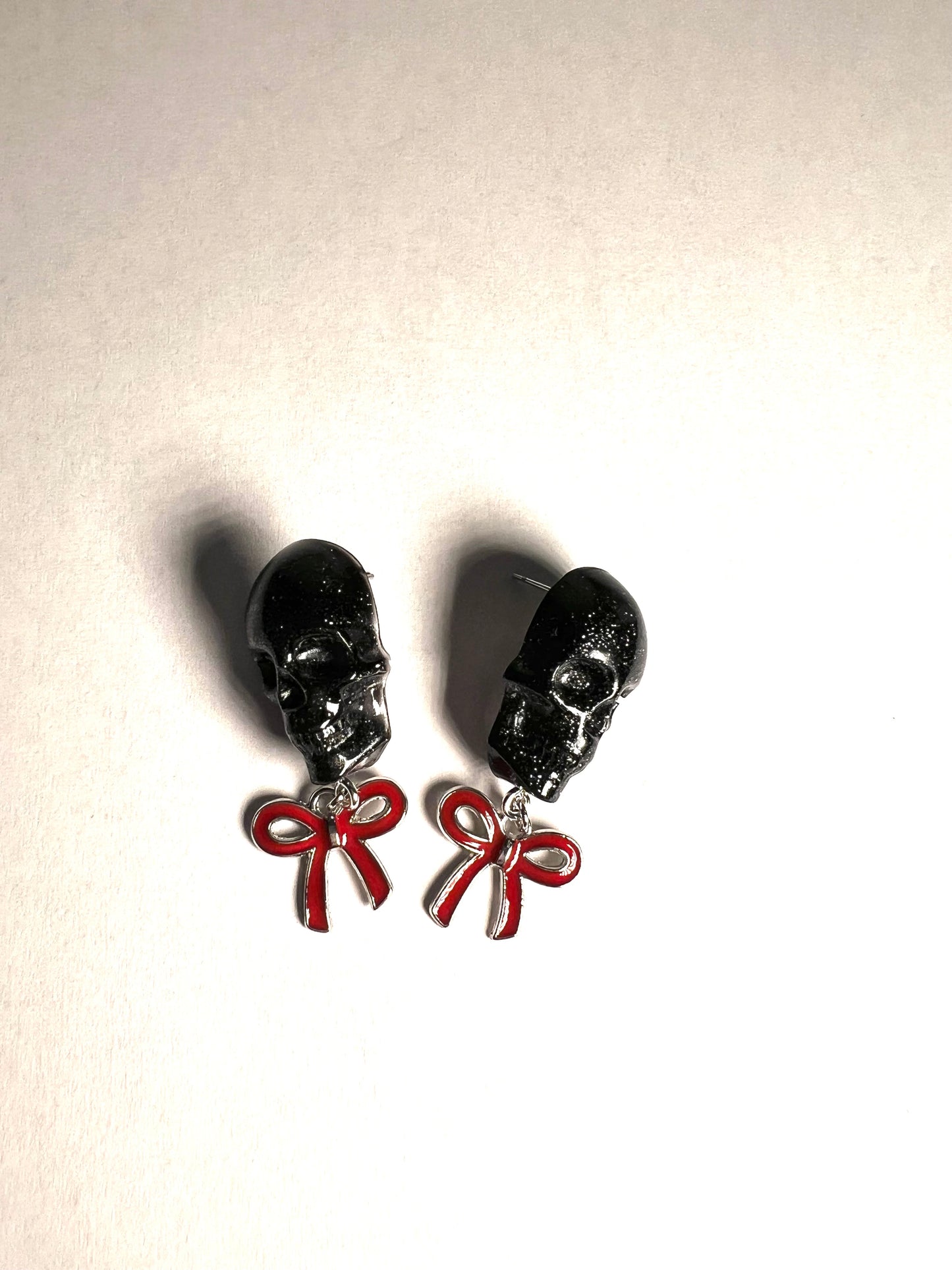 Skull with red bow and silver metal earrings studs