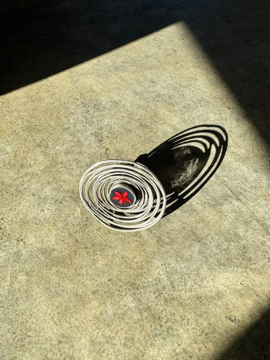 Oversized spiral silver ring with red flower on a navy background