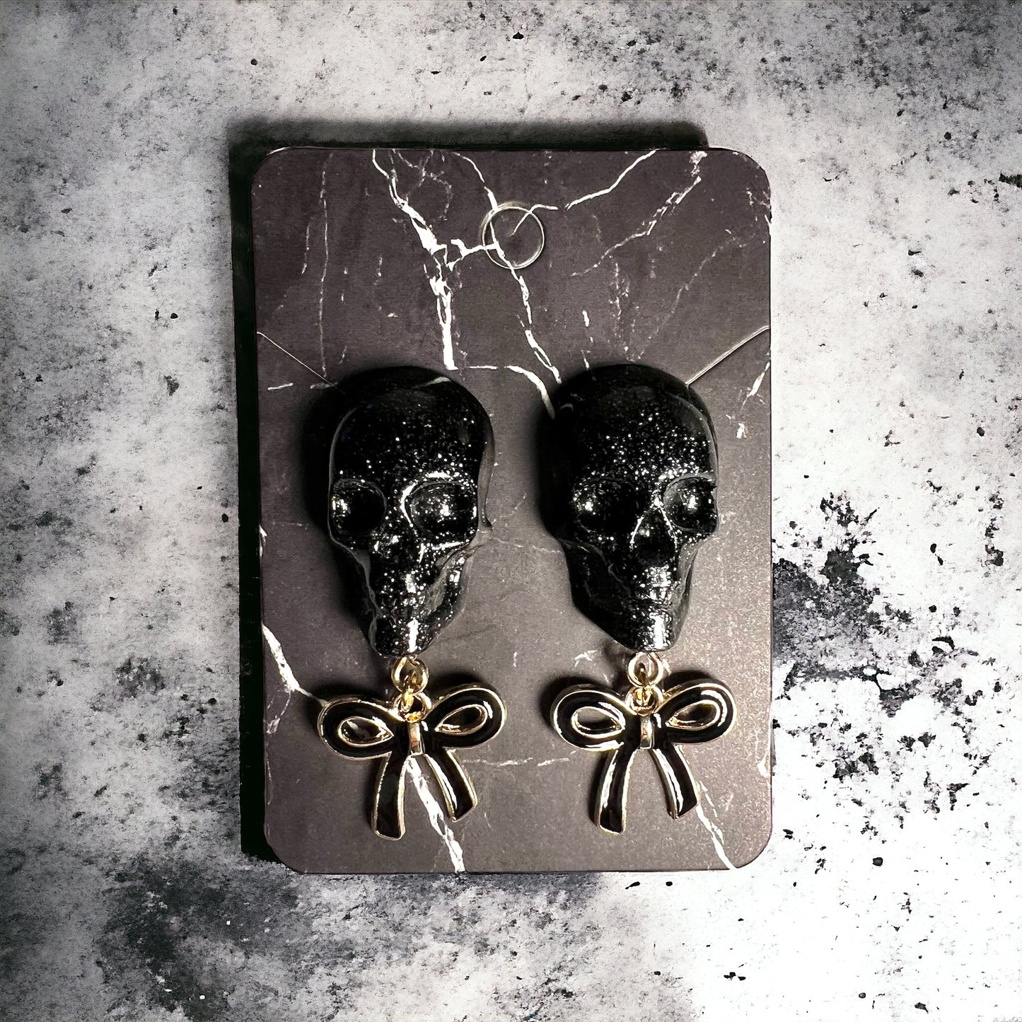 Skull with black bow and gold metal earrings studs