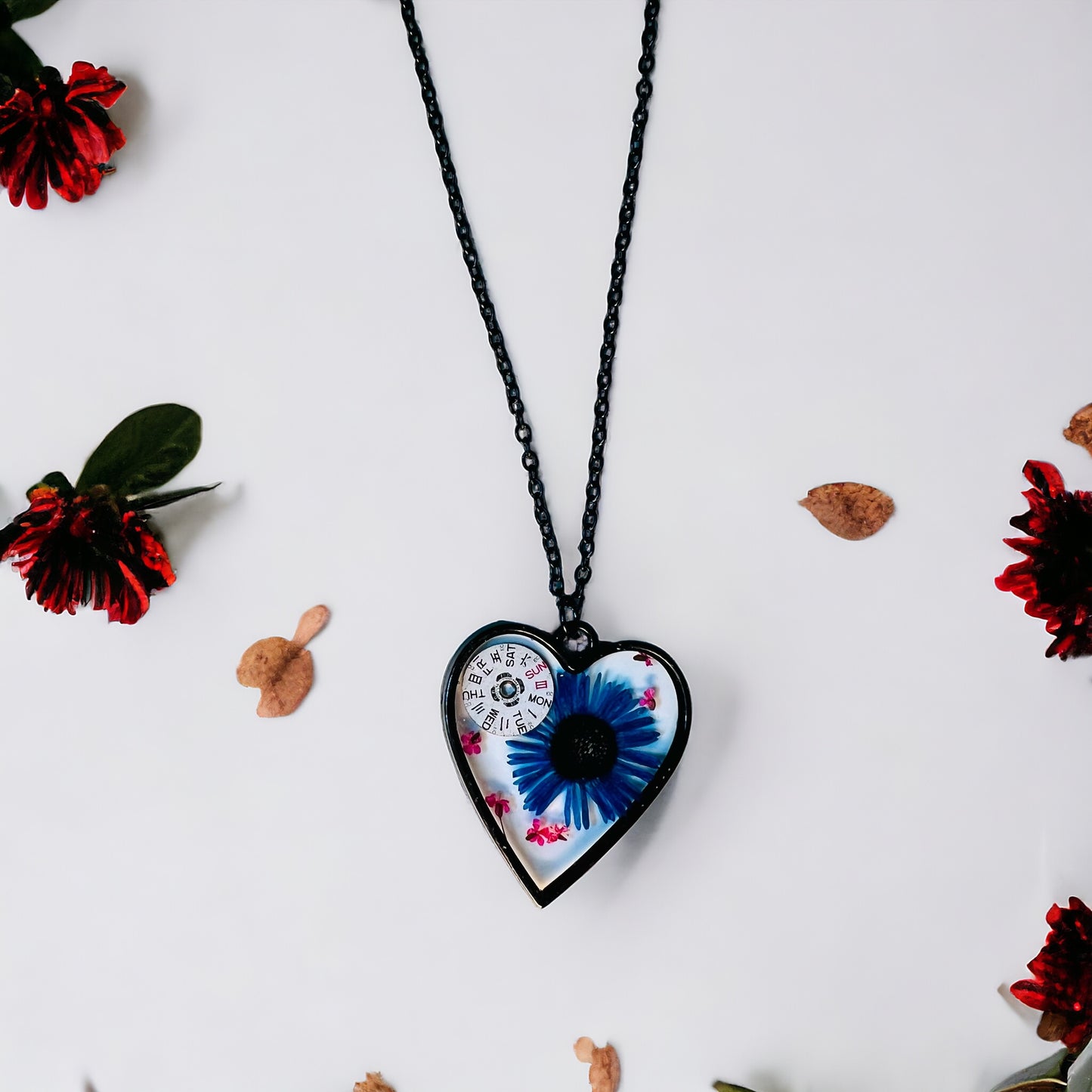 Black Heart necklace with blue chrysanthemum and pink Queen Anne lace flowers and watch parts